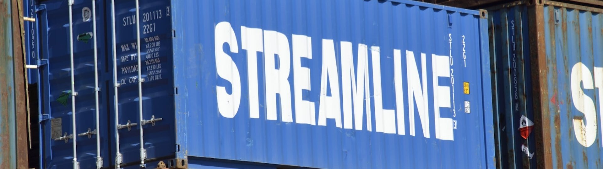 A large blue shipping container with the text Streamline on the side in white